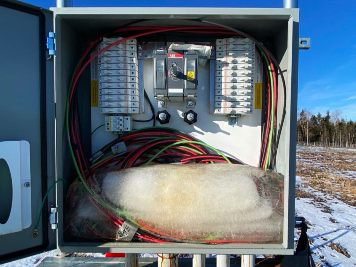 tsr-energy-frozen-solar-combiner-water-intrusion Open solar combiner box with ice buildup caused by water intrusion.