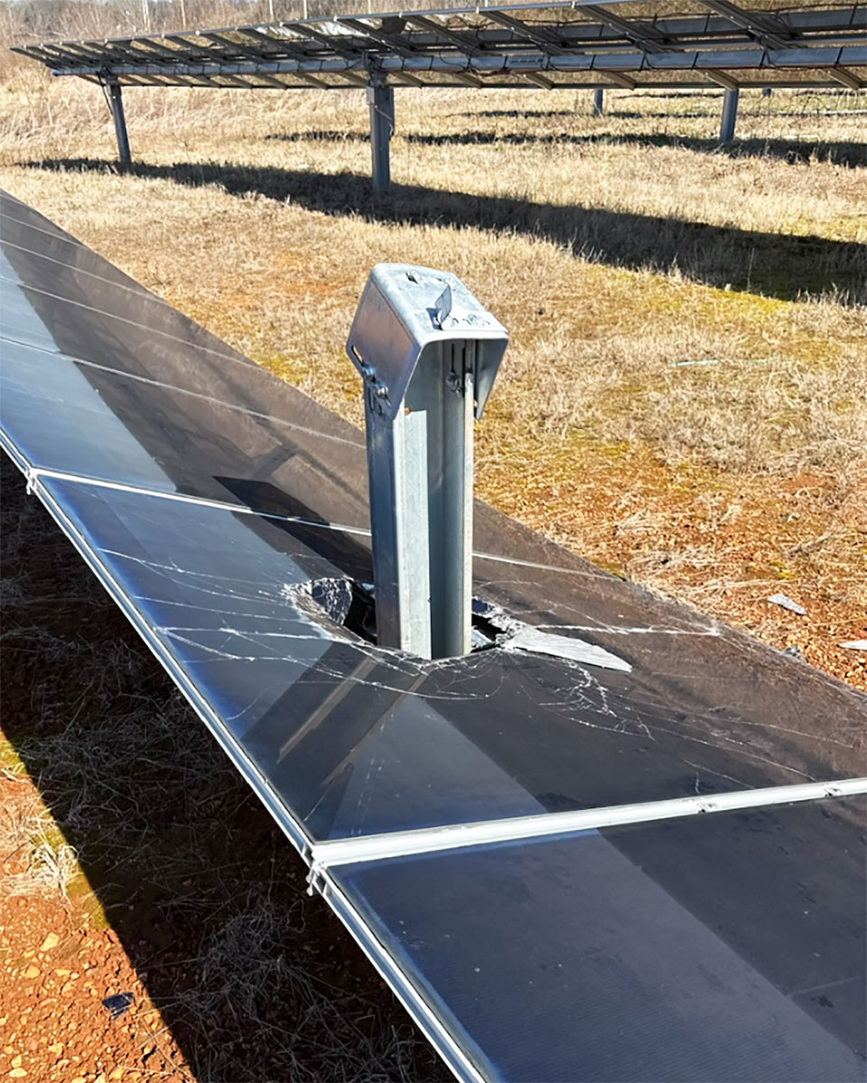 Solar module shattered after contact with a tracker support post on a ground-mounted array.